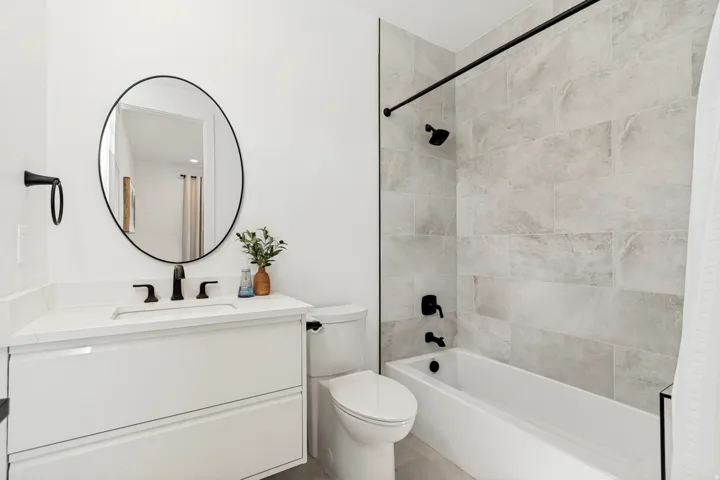 Bathroom with white vanity, integrated sink, and quartz countertop