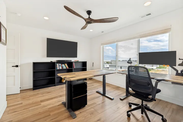 Bright interior space featuring wood-finish flooring and a modern ceiling fan