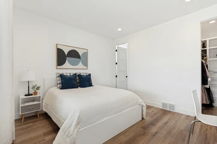 Bedroom featuring wood-finish flooring, recessed lighting, and a built-in closet system with shelving