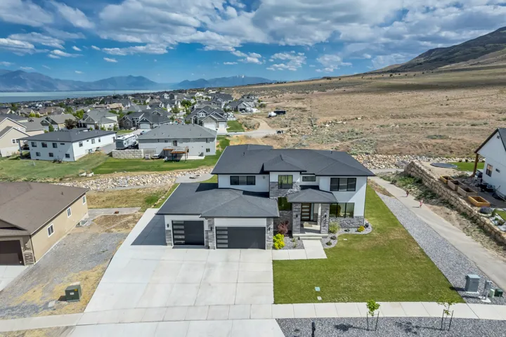 Modern two-story residence featuring a black shingle roof and a white and grey stone facade