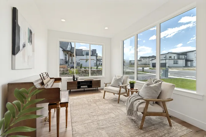 Bright interior space featuring large windows, recessed ceiling lighting, light wood-finish flooring, and a neutral wall color