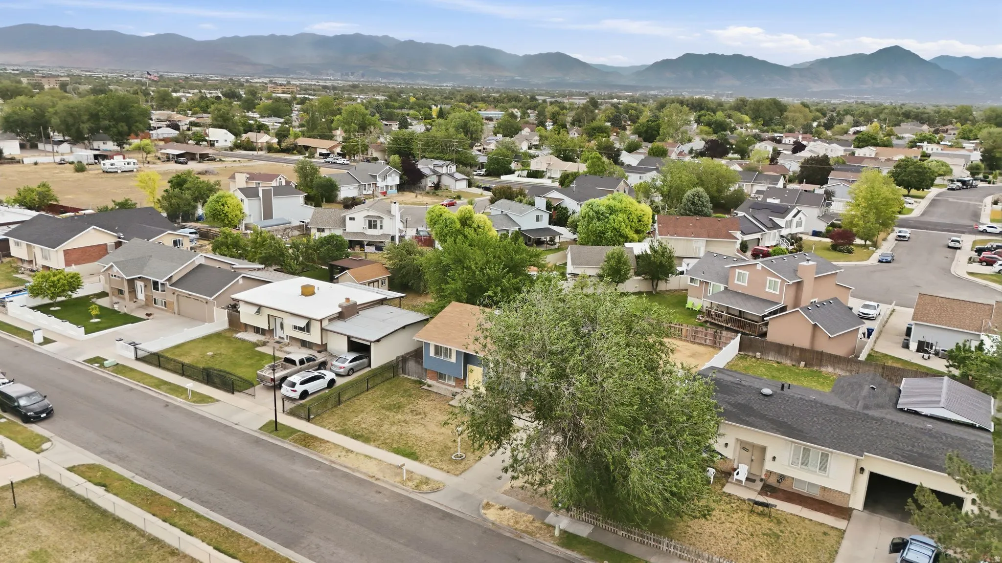 Neighborhood street with single-family homes and mountain backdrop
