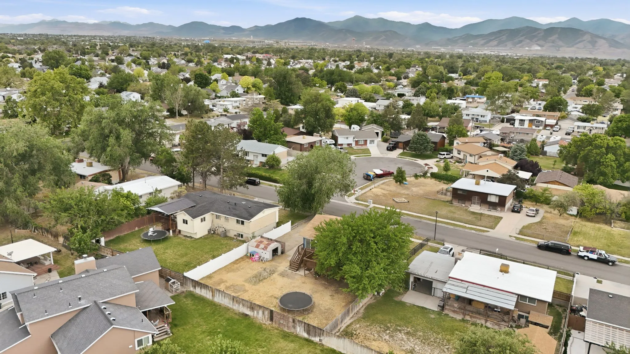 Suburban residential neighborhood featuring a variety of single-family homes, mature trees, and paved streets