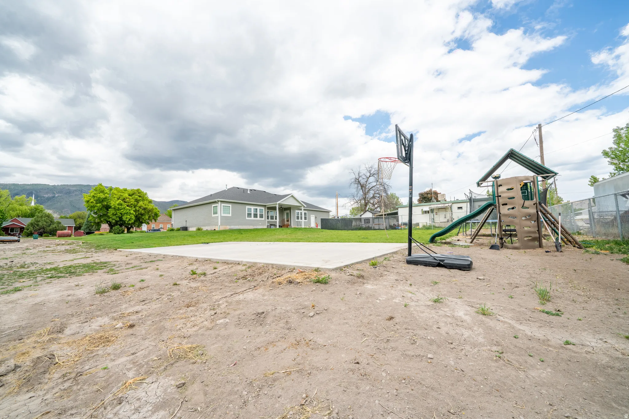 Spacious backyard featuring a concrete sports court.