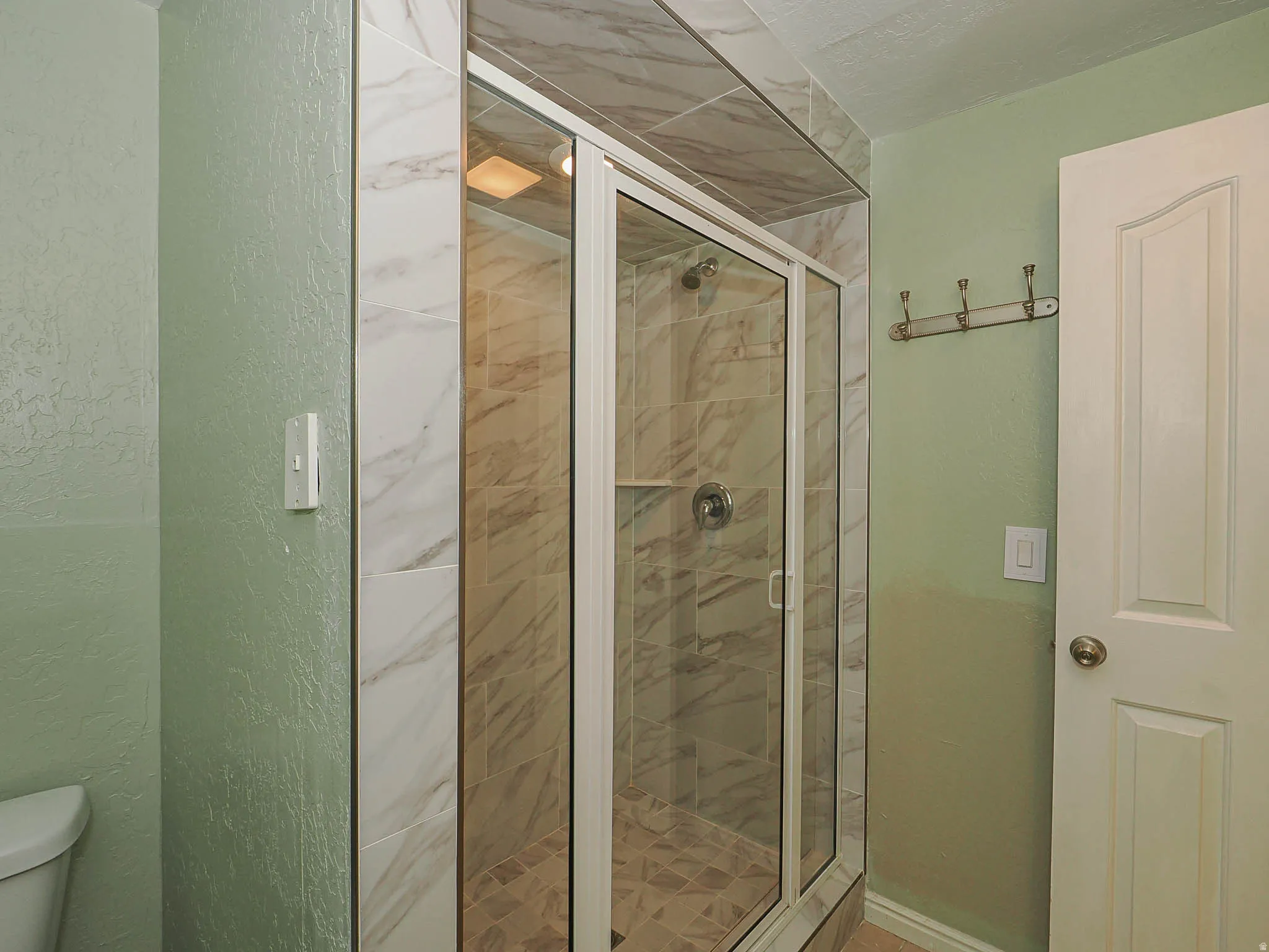 Glass-enclosed shower with tiled walls and floor