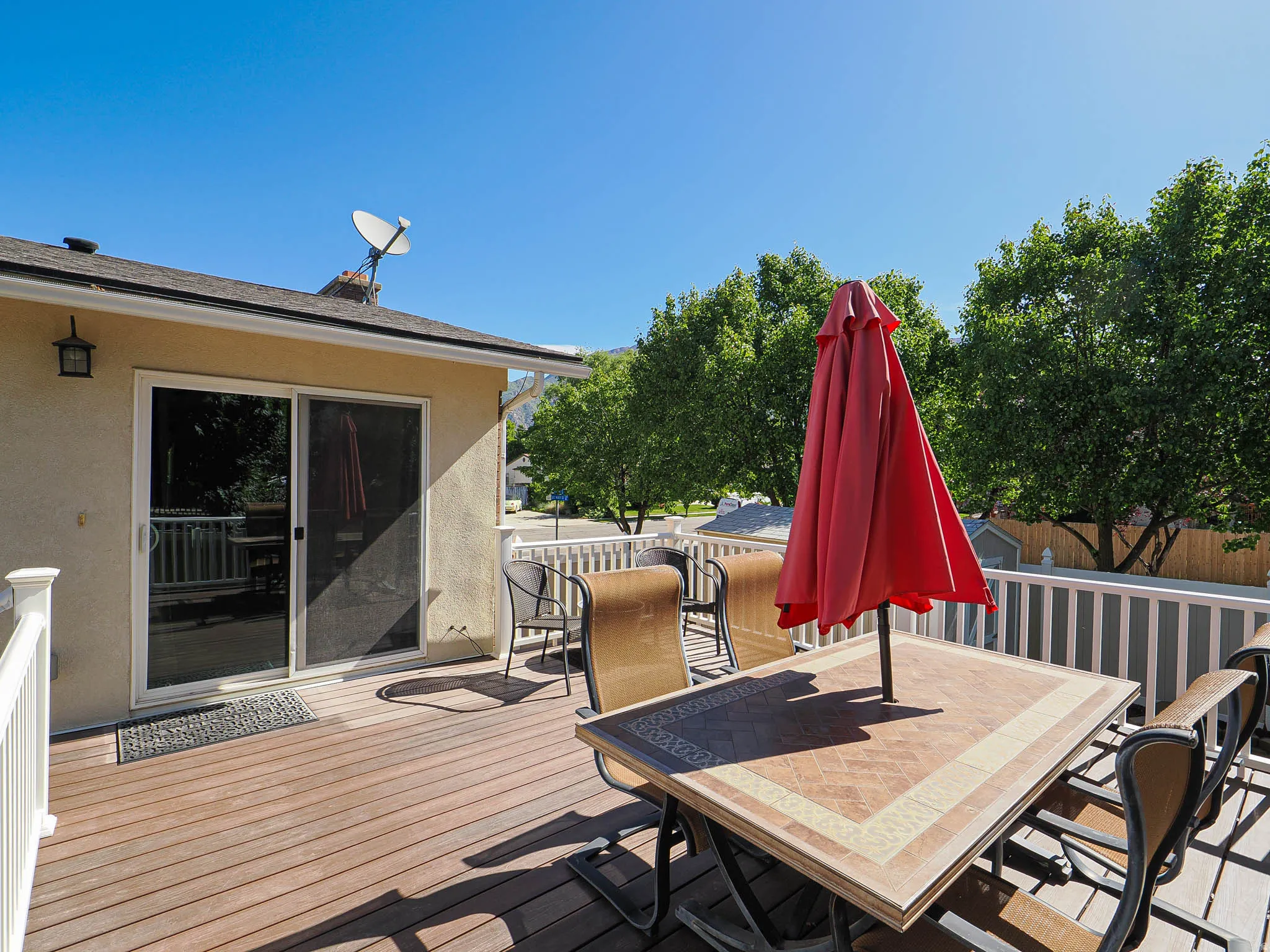 Spacious outdoor deck featuring wood-finish flooring and white railings