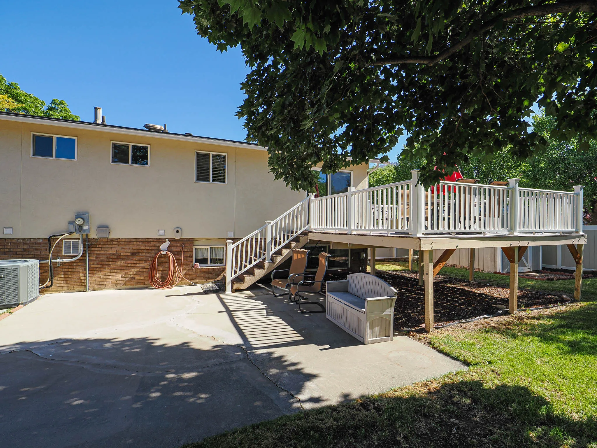Spacious outdoor deck with white railings and staircase, providing elevated outdoor living
