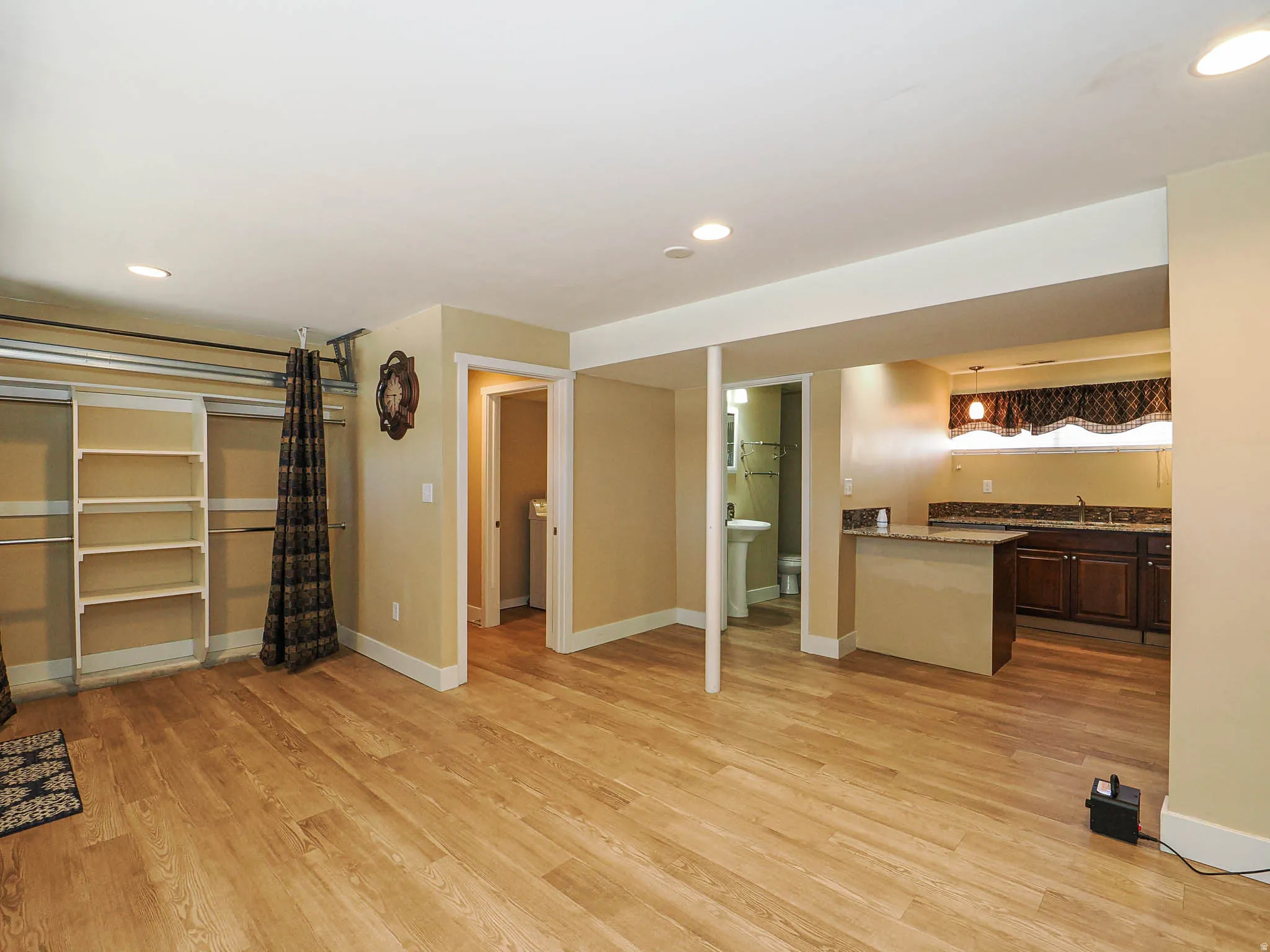 Open concept area featuring wood-finish flooring, recessed lighting, and a built-in shelving unit
