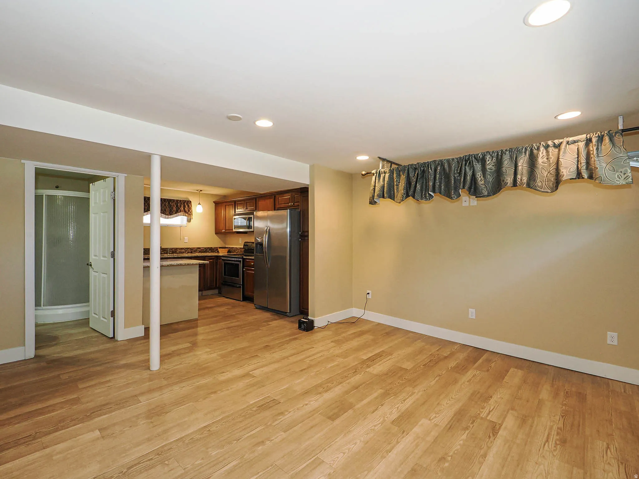 Open-concept lower level featuring wood-finish flooring and recessed lighting
