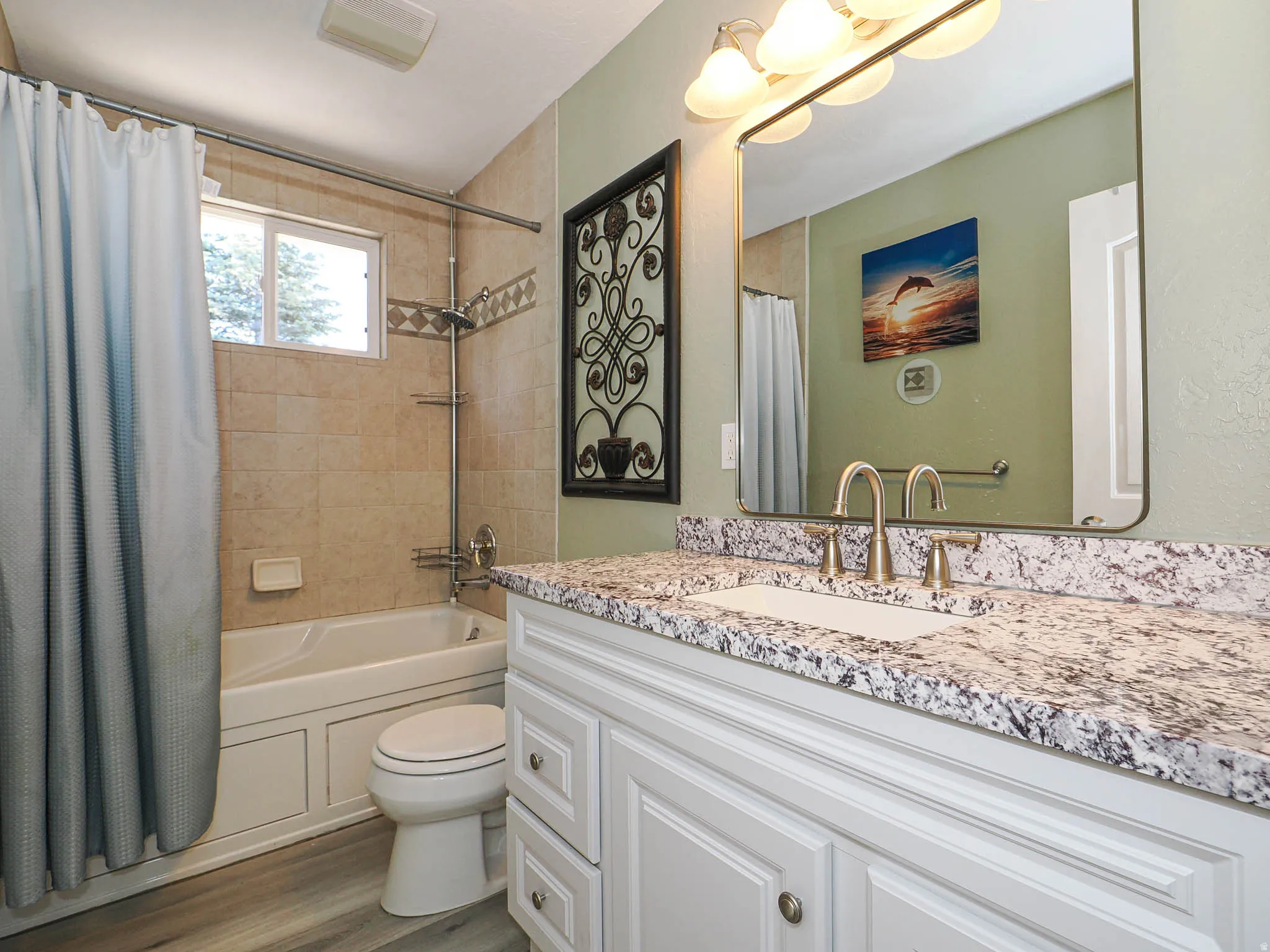 Bathroom featuring a single vanity with a speckled countertop, a drop-in sink, and a brushed nickel faucet