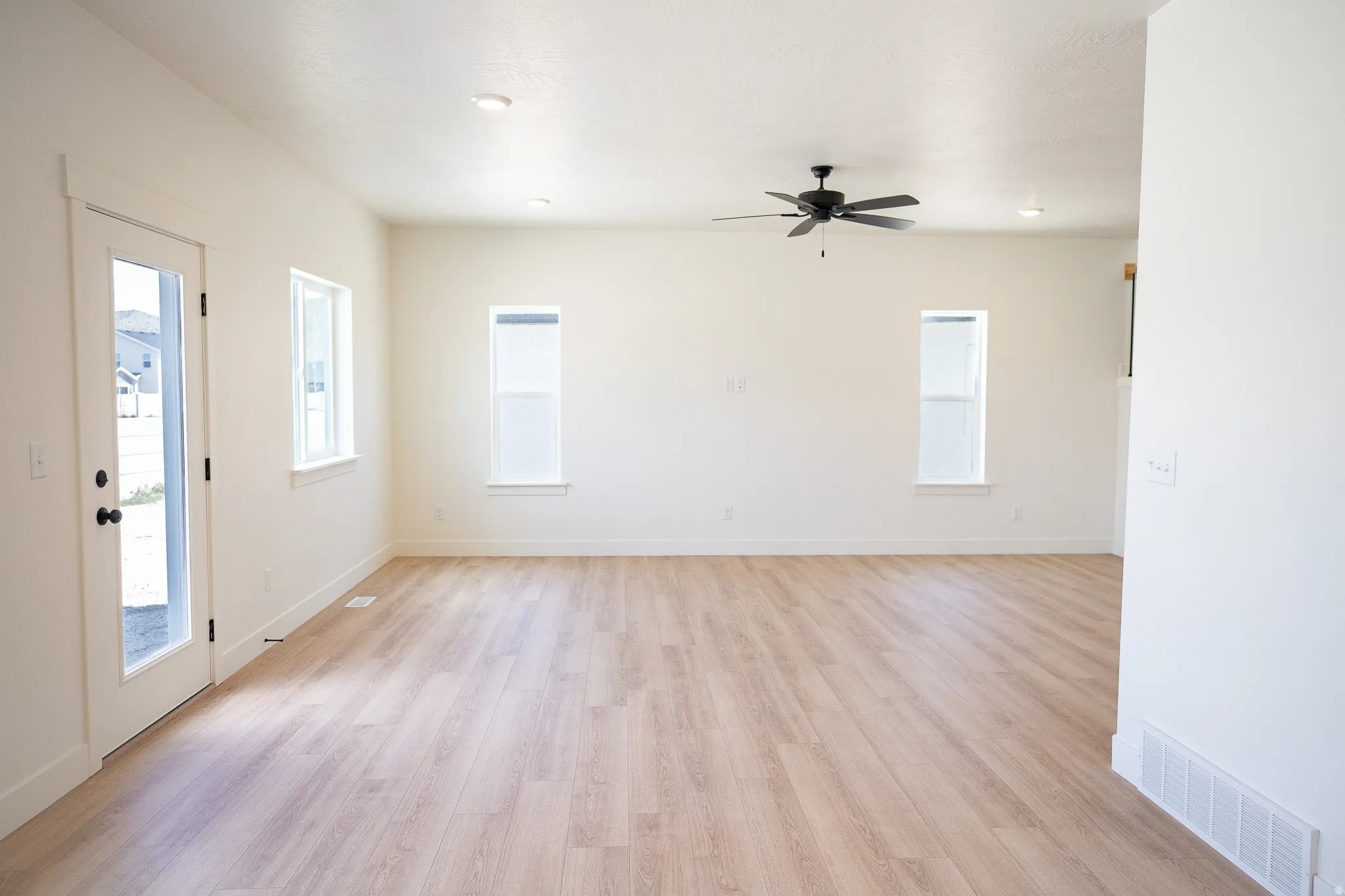 Family room with 9' ceiling and ceiling fan.