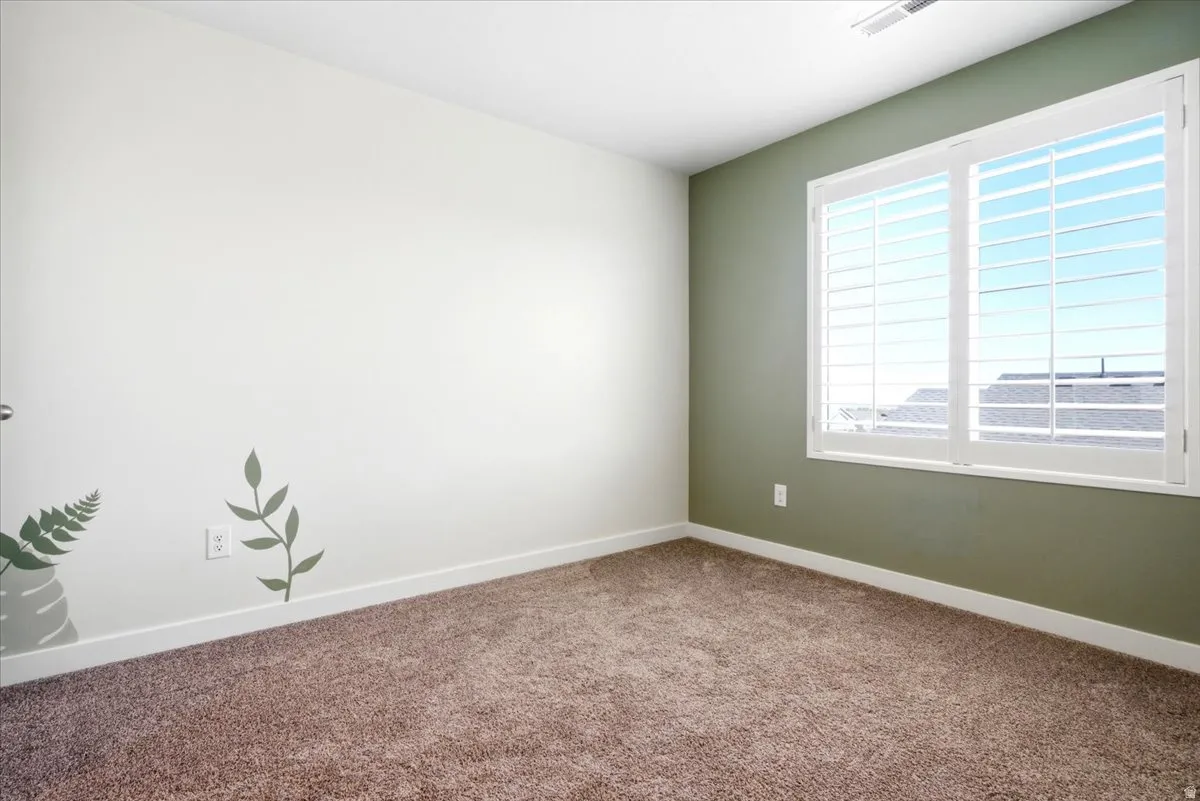 Bedroom featuring two-tone walls, white baseboards, and brown carpeting