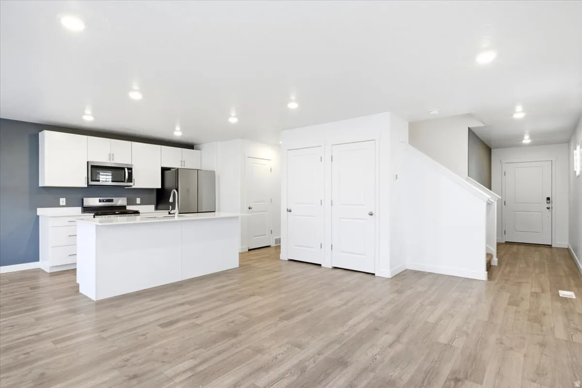 Open-concept interior featuring light wood-finish flooring throughout
