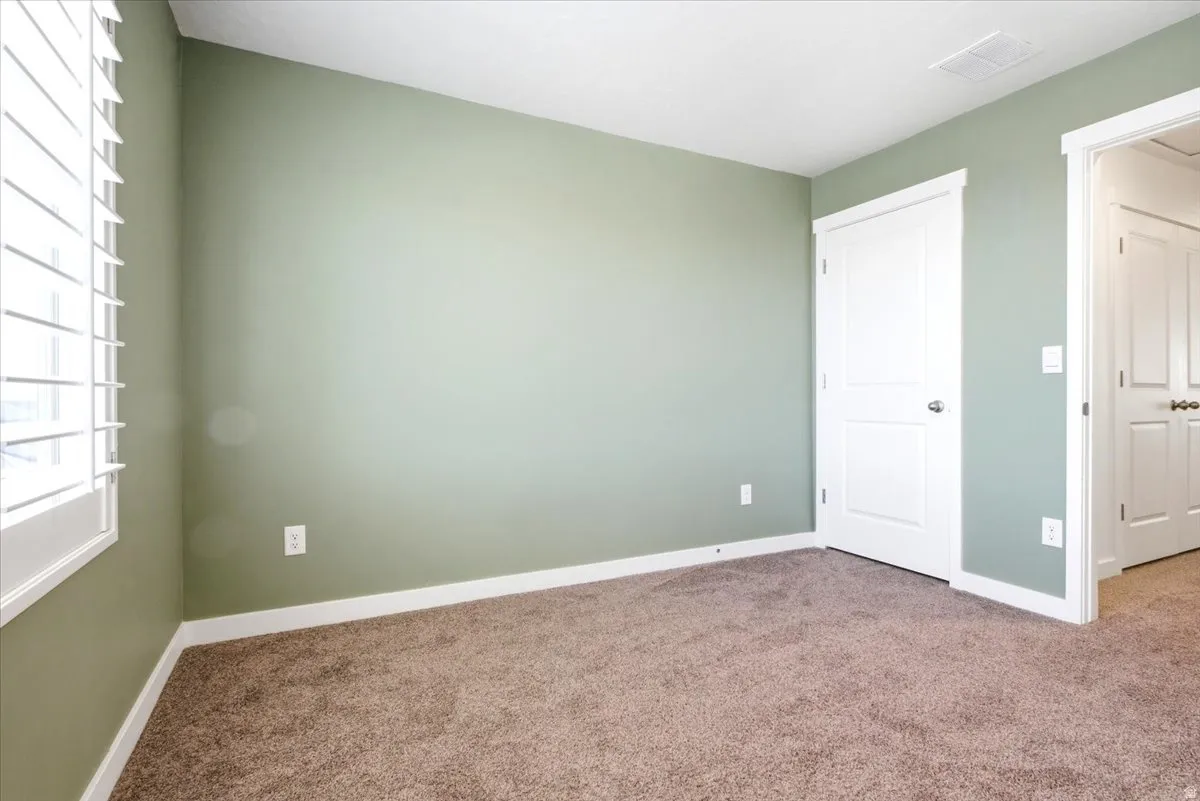 Room featuring neutral carpeting and light green walls