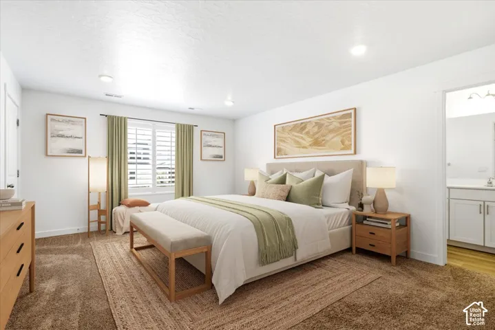 Virtually Enhanced. Primary Suite. Recessed lighting, window with plantation shutters, wood-finish flooring, white cabinetry with silver-tone hardware, and white countertops