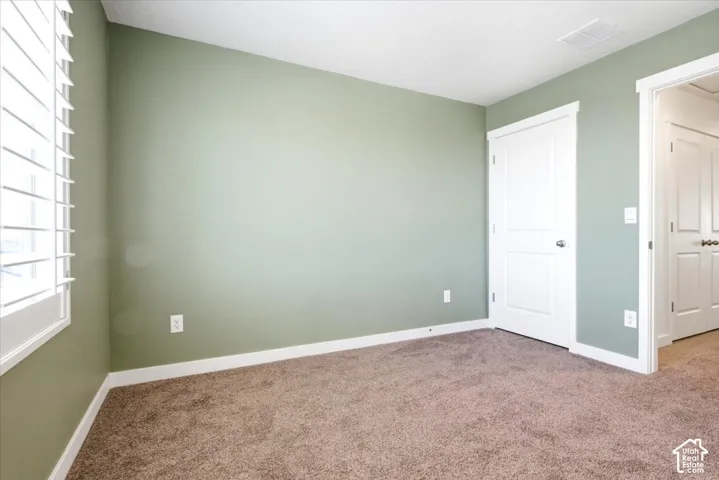 Room featuring neutral carpeting and light green walls