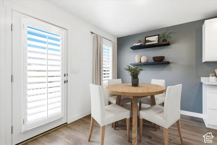 Virtually Enhanced. Wood-finish flooring, white cabinetry, dark accent wall, and built-in floating shelves