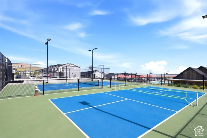 Recreational facility featuring multiple courts with blue playing surfaces and green surrounds