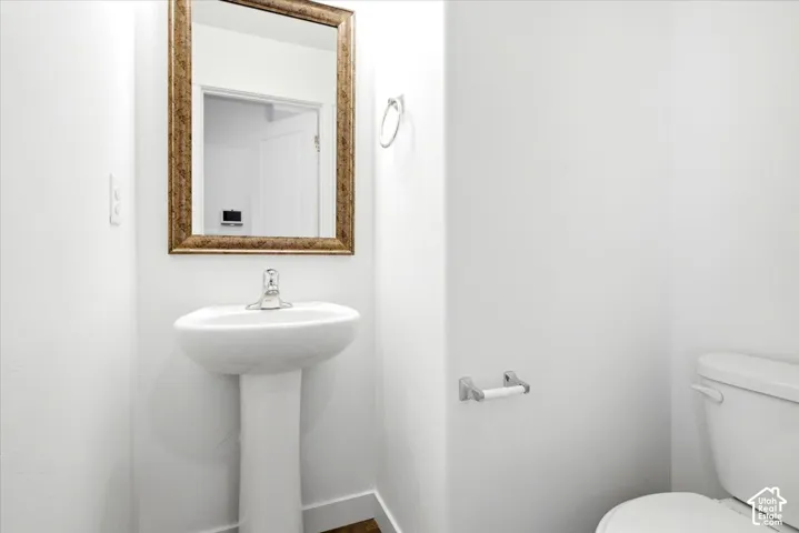 Pedestal sink with a polished chrome faucet and a framed mirror