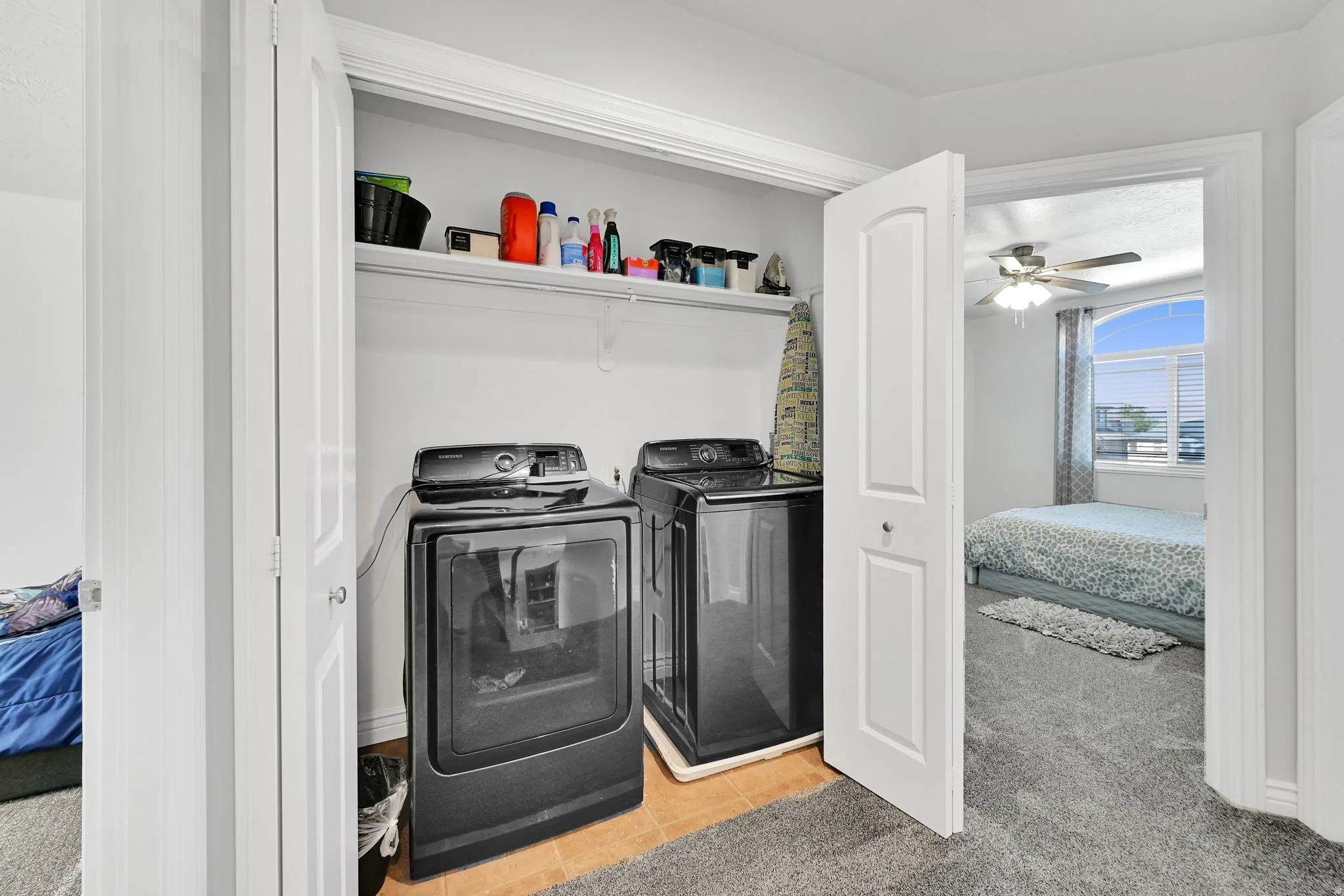 Dedicated laundry closet featuring a built-in shelf, bi-fold doors, and neutral wall tones