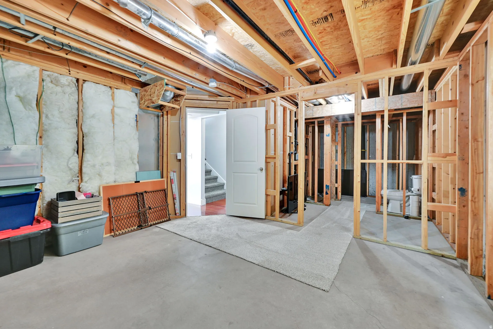 Unfinished basement with concrete flooring and exposed ceiling joists