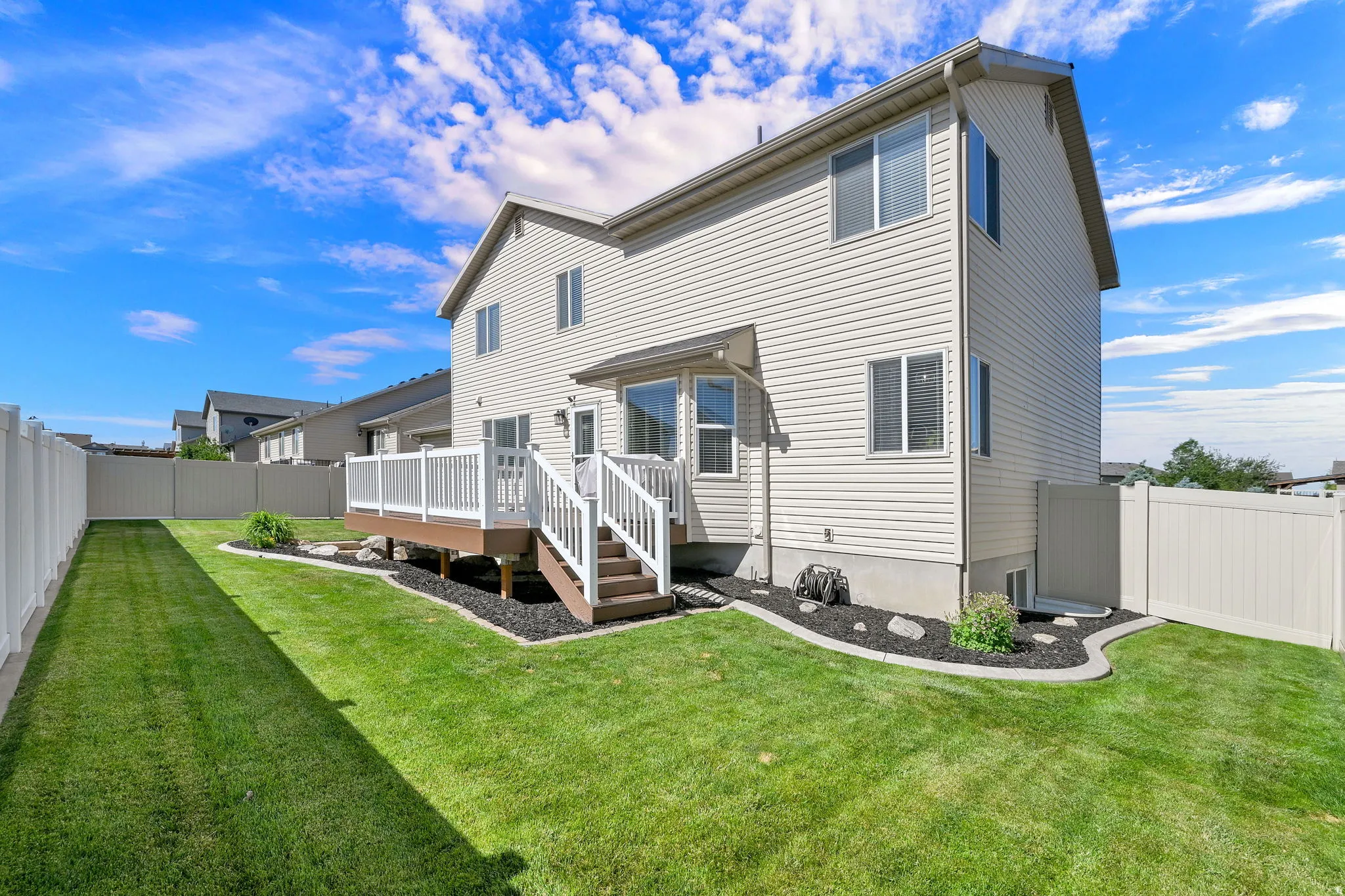 Rear exterior featuring a composite deck with white railings and steps