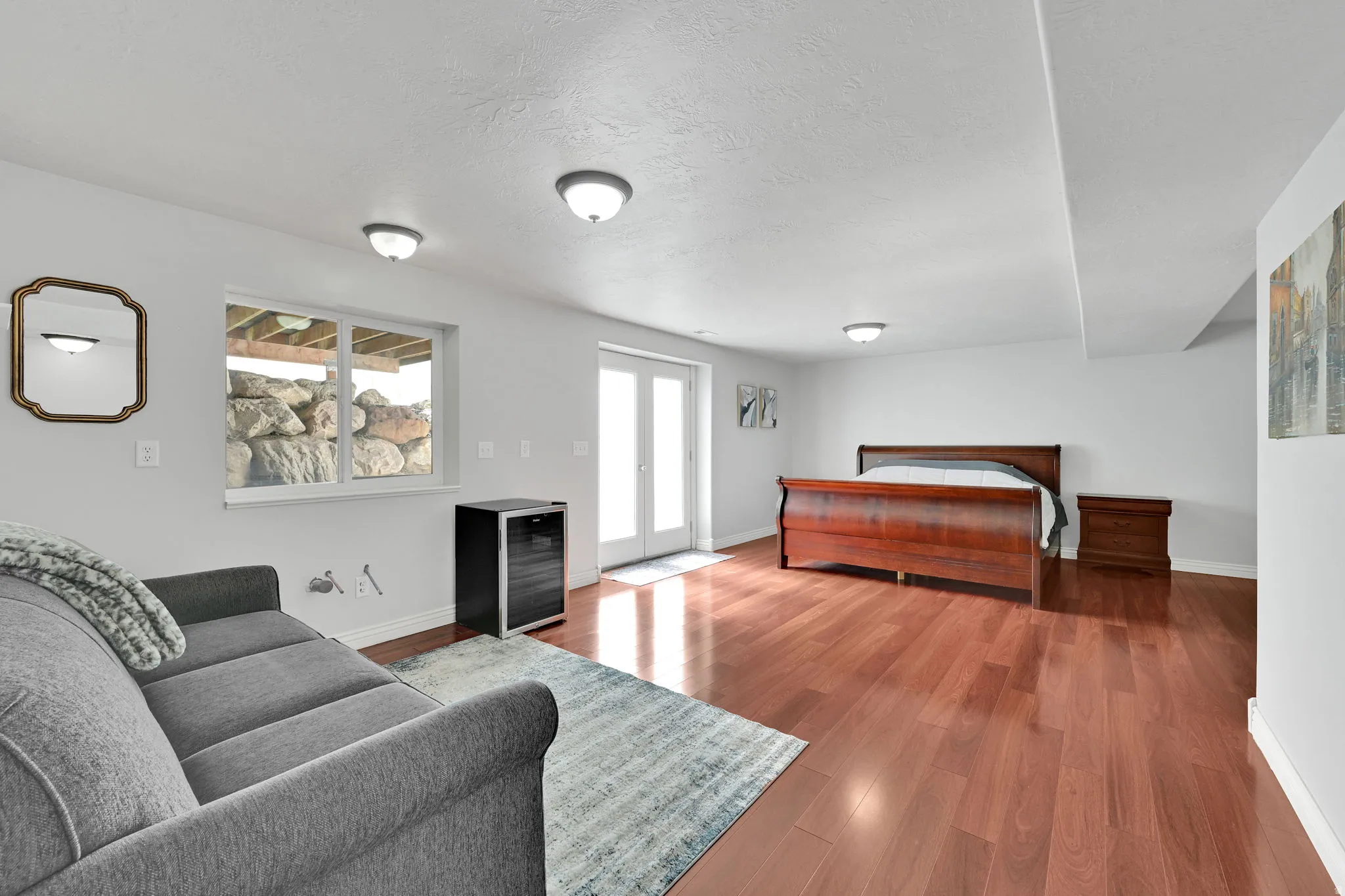 Spacious room featuring wood-finish flooring, white walls, and recessed lighting
