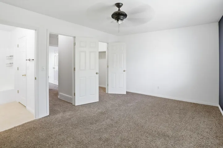 Carpeted room with white walls and a dark accent wall