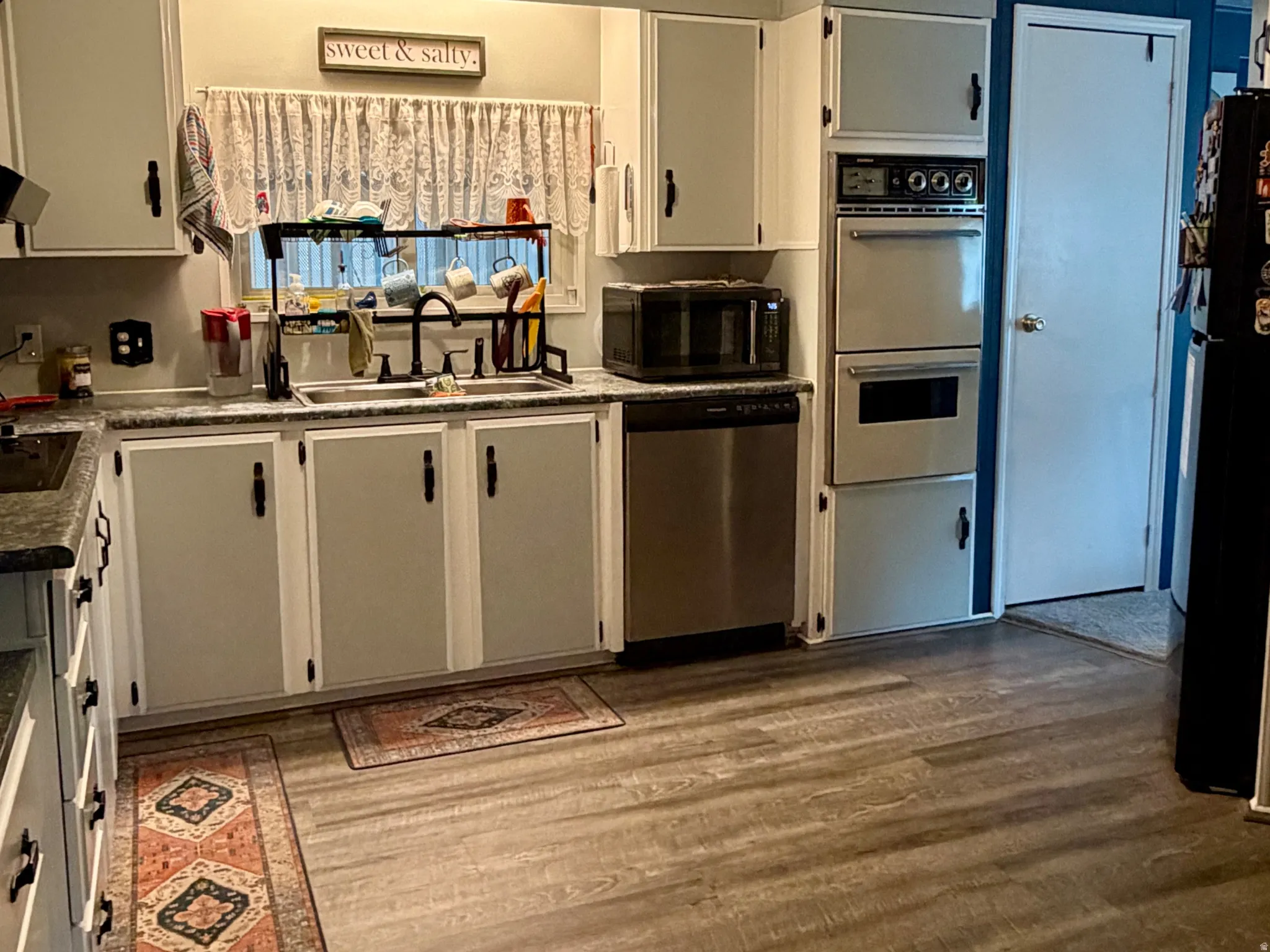 Kitchen featuring built-in double oven and stainless steel dishwasher