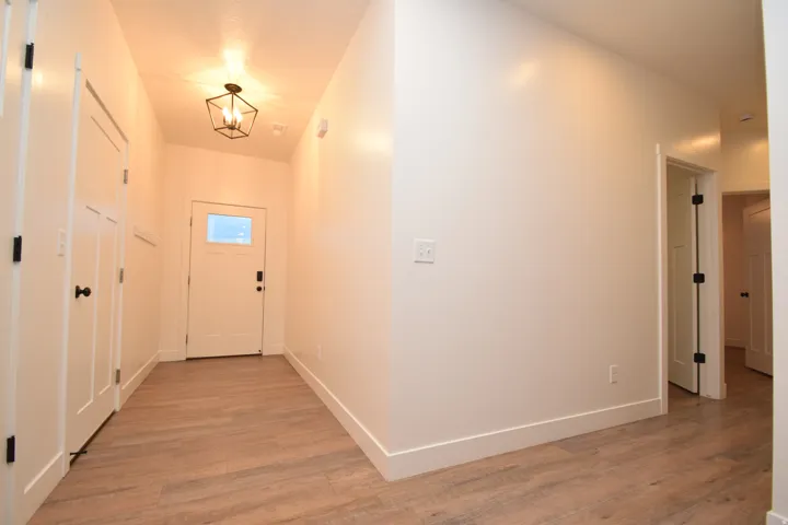 Entryway featuring light wood-finish flooring, white walls, and a contemporary geometric ceiling light fixture