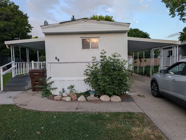 White horizontal siding exterior with a covered front porch and a paved driveway