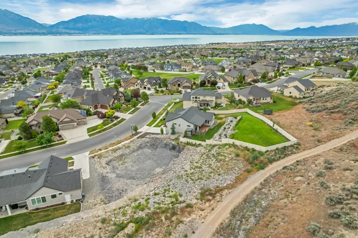 Expansive residential parcel featuring a prepared building site, surrounded by existing homes