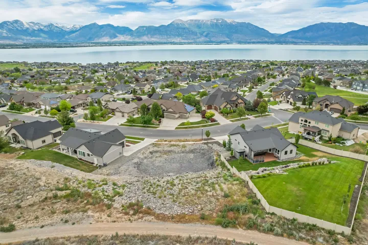 Aerial perspective showcasing a residential neighborhood with a large body of water and distant mountains