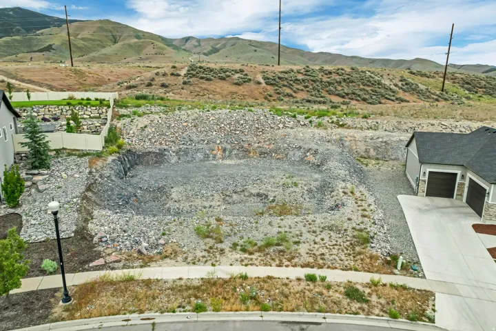 Excavated lot featuring a leveled building pad and surrounding rocky terrain