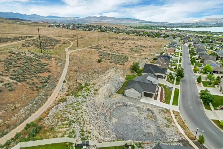 Aerial perspective showcasing a residential street with homes featuring dark gray roofing and light-toned siding