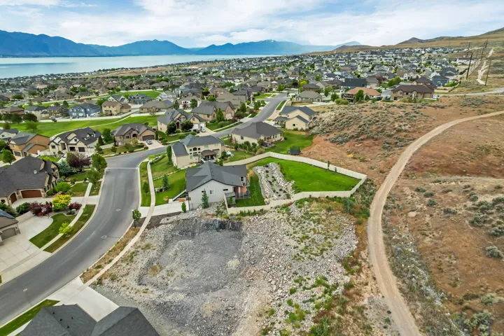 Aerial perspective showcasing a residential neighborhood with a large body of water and distant mountains