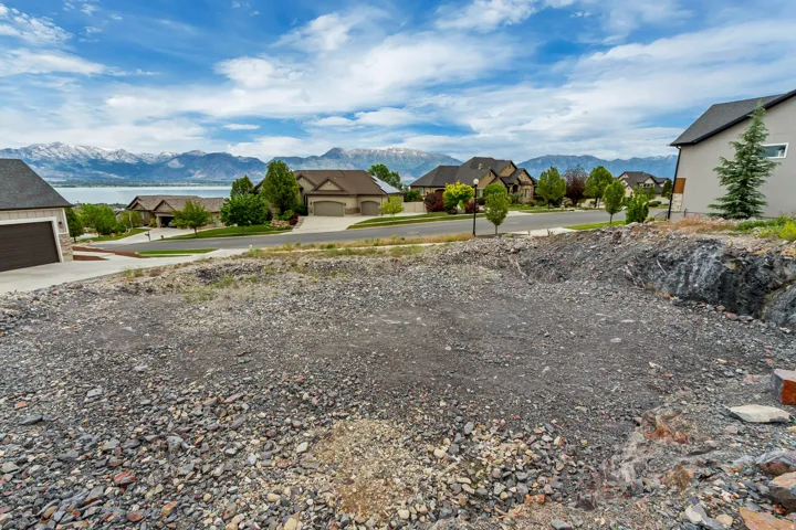 Expansive buildable lot with a clear graded area, featuring distant lake and mountain scenery