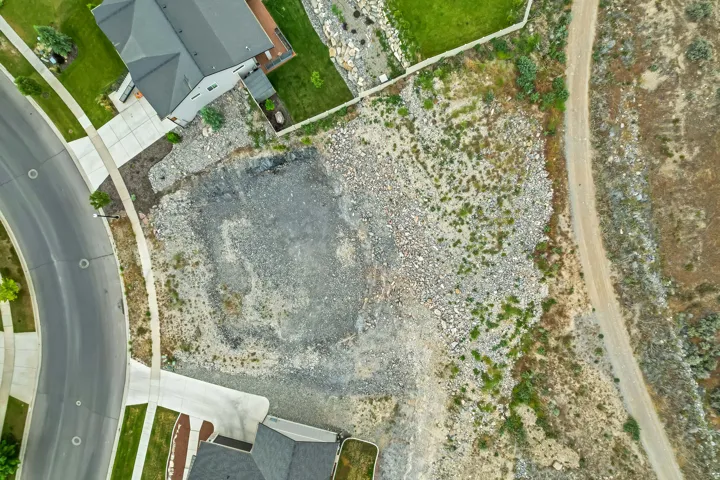 Vacant lot featuring a prepared building pad, direct street frontage, and established curb and gutter infrastructure