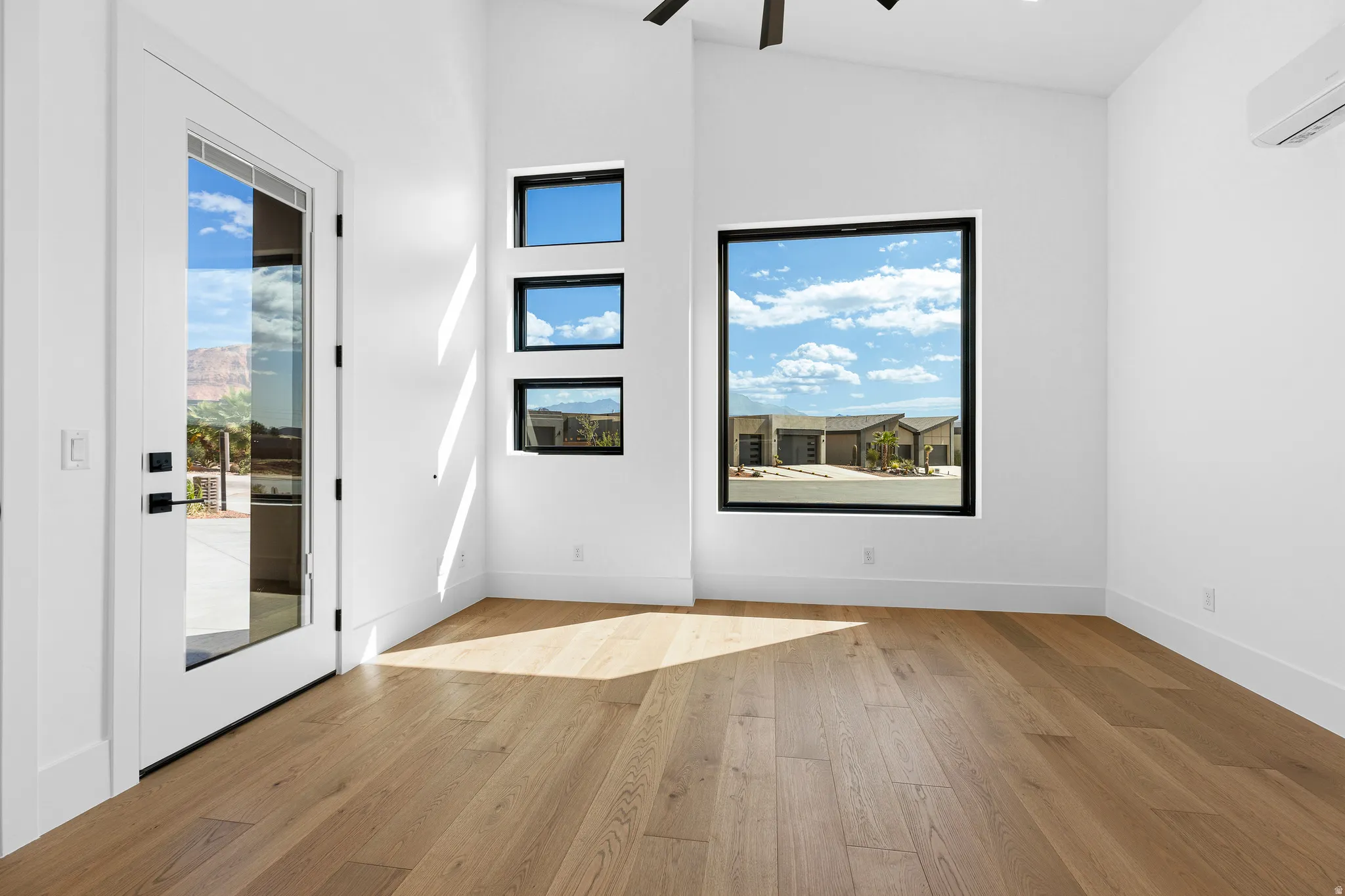 Light wood-finish flooring complements white walls and tall baseboards