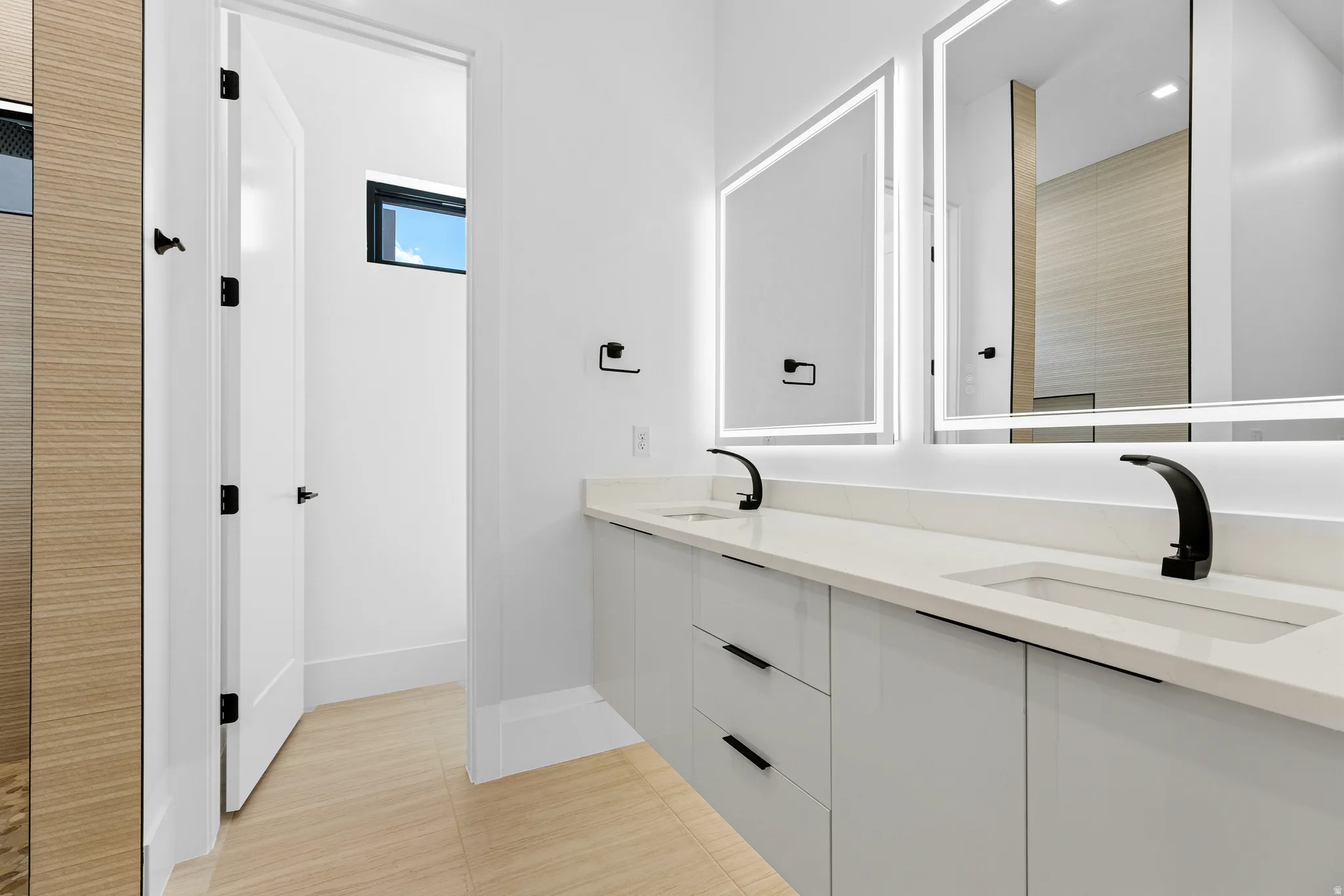 Dual vanity featuring integrated sinks, light-toned countertops, and matte black fixtures