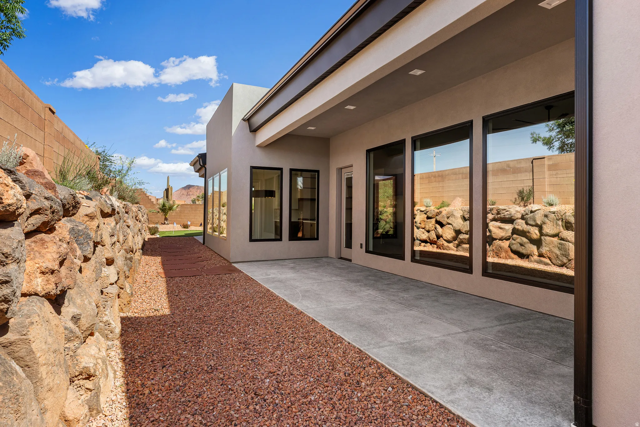 Modern exterior with stucco finish and a covered patio featuring recessed lighting
