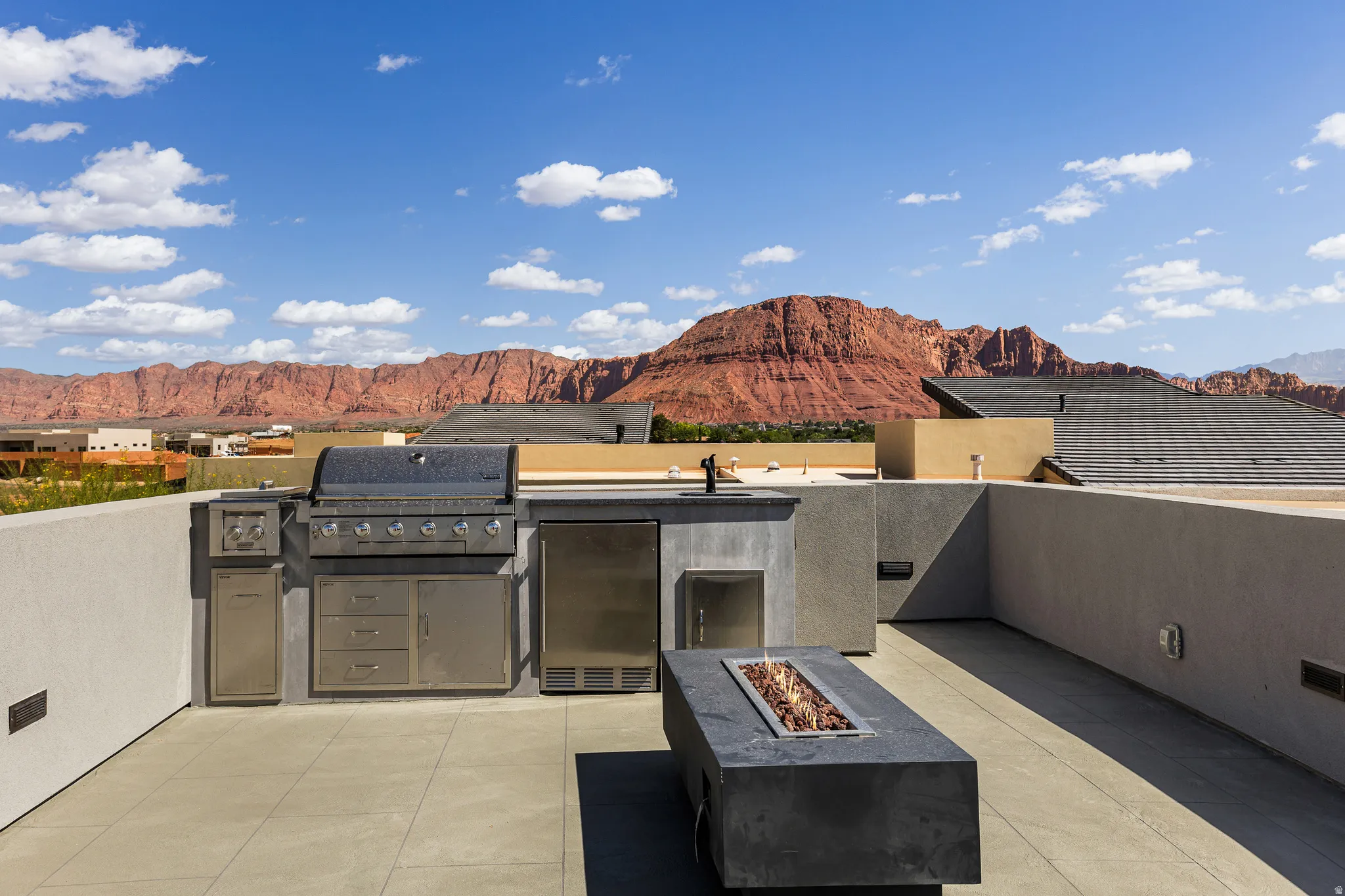 Rooftop patio with a built-in outdoor kitchen, integrated gas grill, and stainless steel appliances