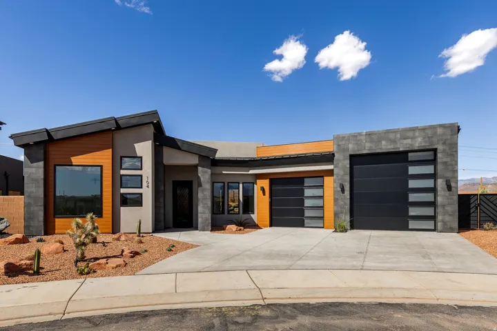 Modern architectural exterior featuring a sloped roofline, wood-finish siding accents, and stone-finish facade elements