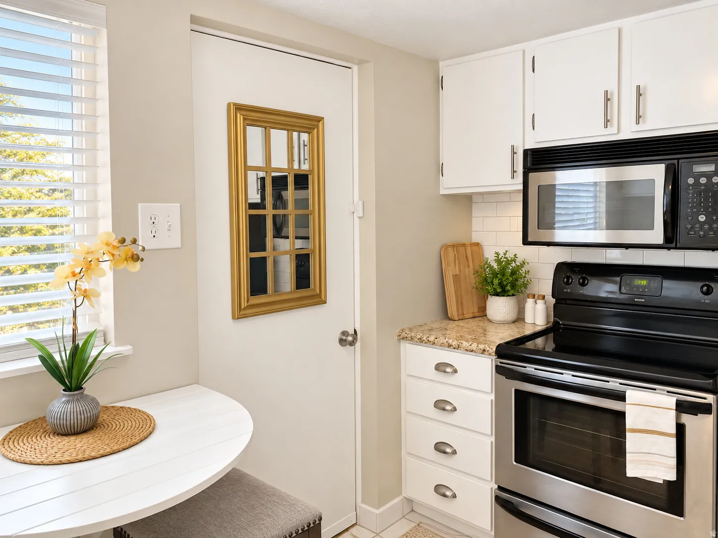 Kitchen featuring white cabinetry, stone-finish countertops, stainless steel appliances, and a tiled backsplash