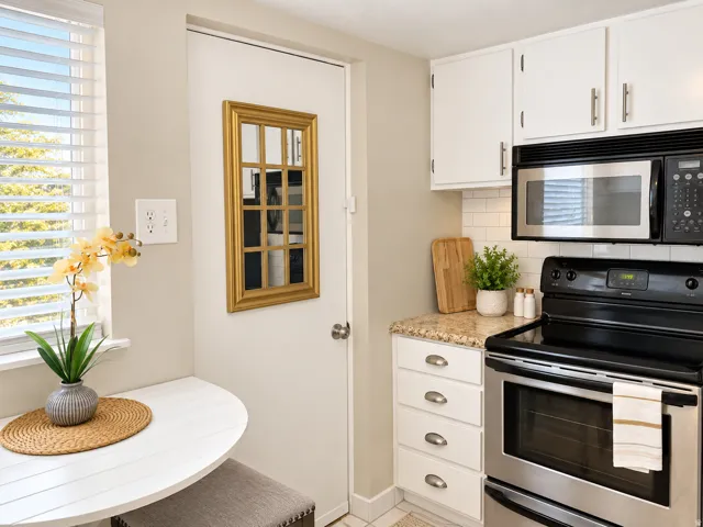 Kitchen featuring white cabinetry, stone-finish countertops, stainless steel appliances, and a tiled backsplash