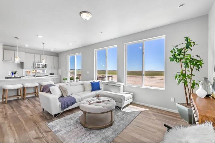 Open-concept living space featuring wood-finish flooring, recessed lighting, and large windows