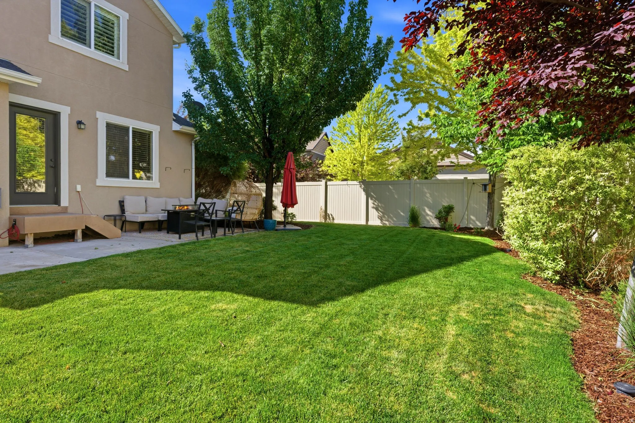 Expansive green lawn with a concrete patio
