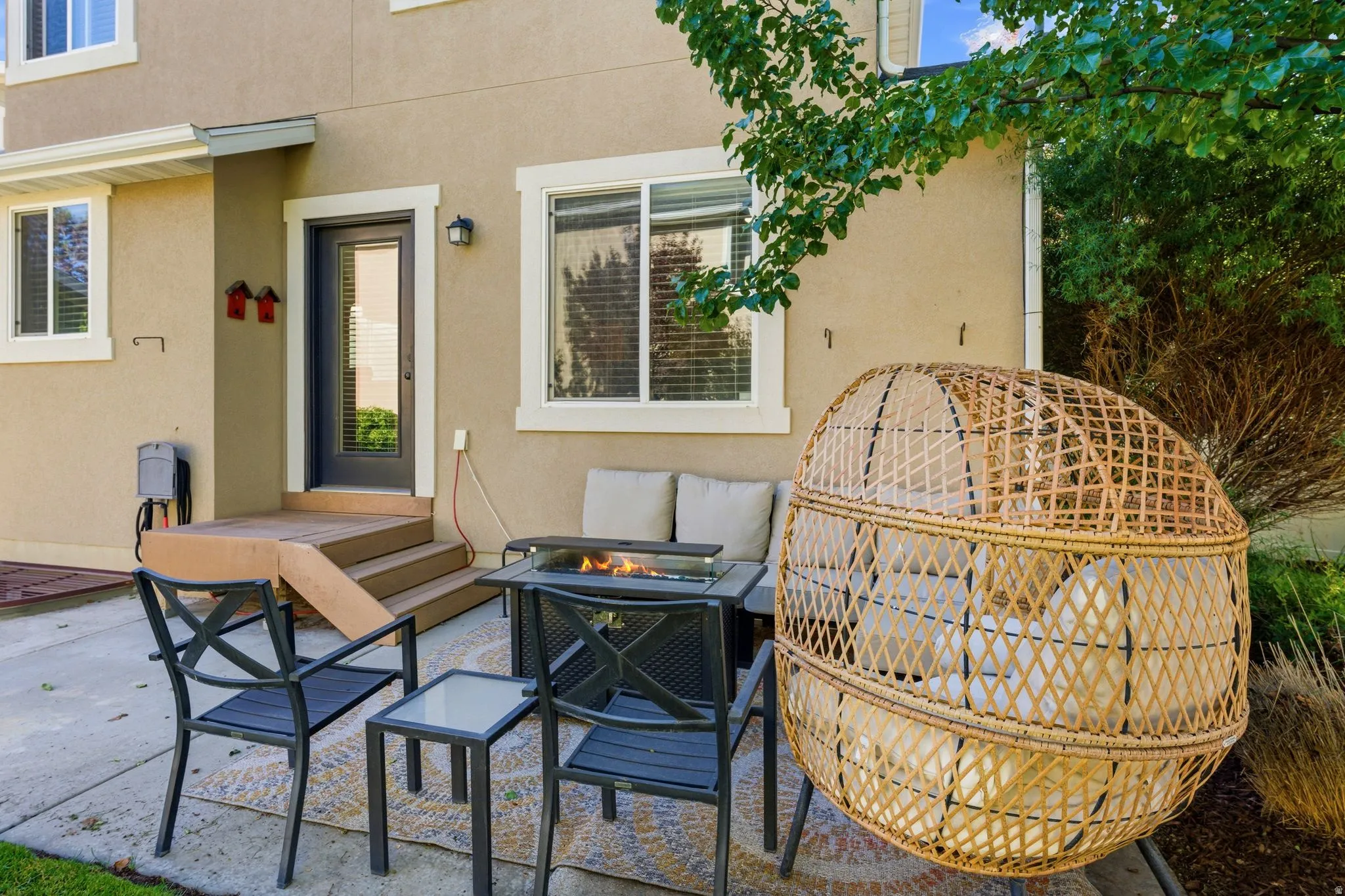 Concrete patio with a wooden deck leading to a rear entry door
