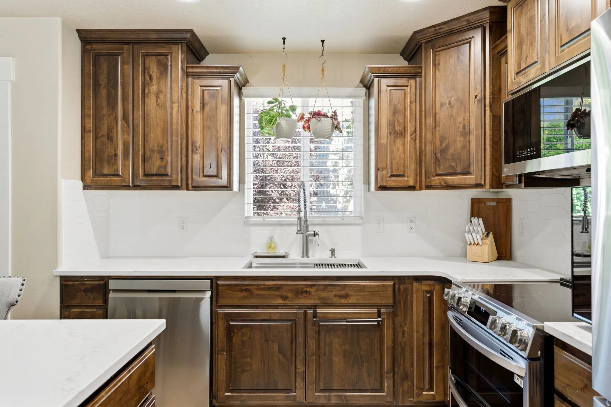 Full kitchen with wood-finish cabinetry, white countertops, and a white subway tile backsplash