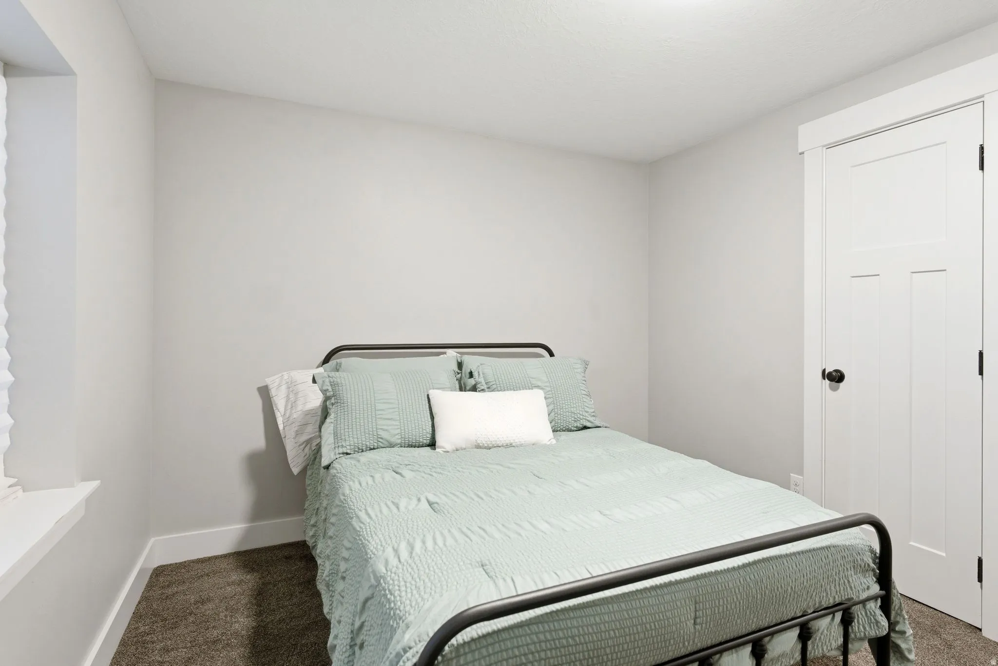 Bedroom featuring light gray walls, dark gray carpeting, and white trim